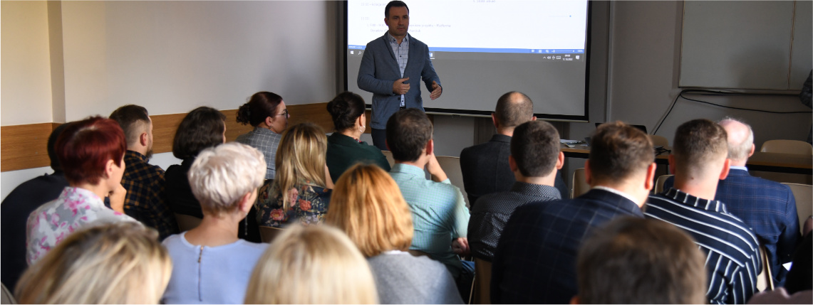 Na konferencji pojawiło się kilkadziesiąt osób Wnętrze sali wykładowej. Dyrektor Jacek Sommerfeld przemawia przed grupą ludzi siedzących na krzesłach.